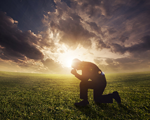 Gleanings from The Religious Affections (Part 21): Distinguishing Sign Six: True Humility Accompanies Gracious Affections - Weekly Blog Post by Dr. Craig Biehl - man kneeling in front of sunset